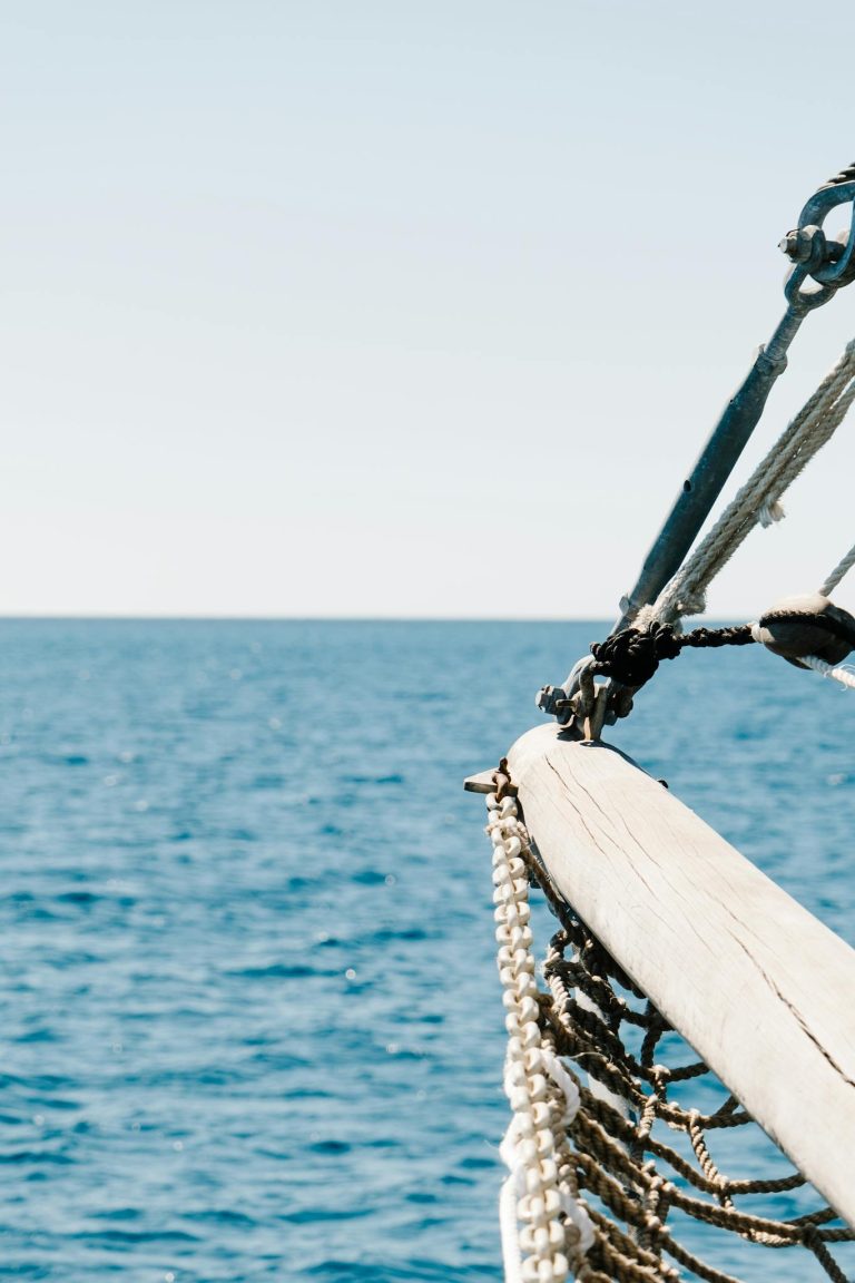 Close-up of a sailboat's ropes overlooking the ocean, capturing nautical detail.